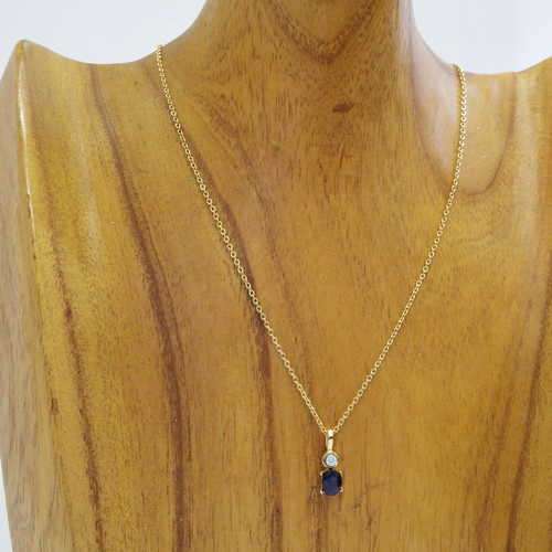 Gold coloured necklace with diamond and sapphire pendant