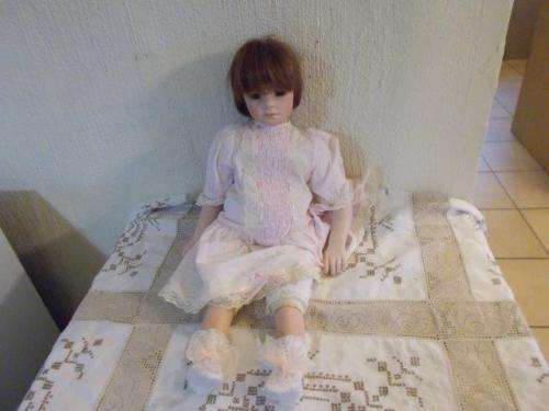 Large porcelain doll wearing a pink dress for you're collection