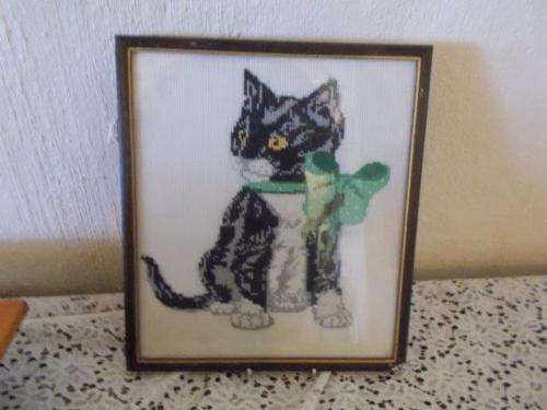 Nice small black kitten tapestry behind glass