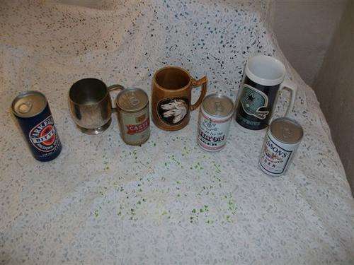 collection of bar beer mugs with old beer cans with the beer still inside the cans