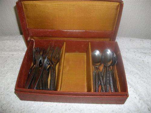 Lot of stainless steel spoons and forks in holder