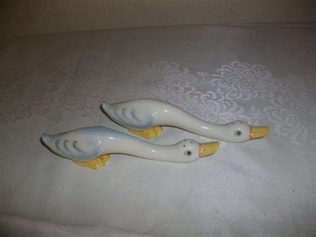 A pair of long duck salt and pepper sharkers