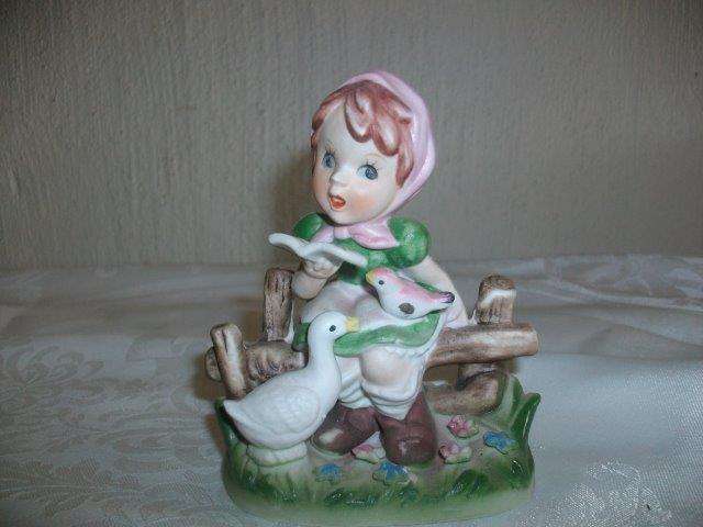 Sweet girl figurine with geese and a bird