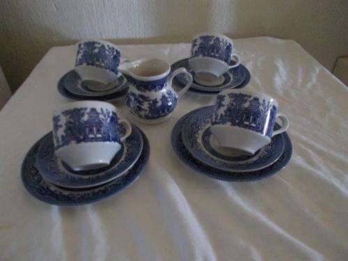Four lovely blue and white willow pattern tea cup trios with milk jug