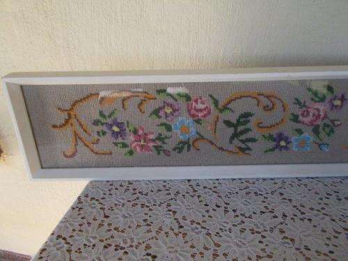 long framed floarl tapestry behind glass