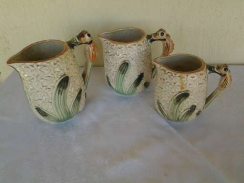 A set of three vintage bee style porcelain decorative porcelain jugs