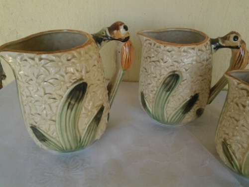 A set of three vintage bee style porcelain decorative porcelain jugs