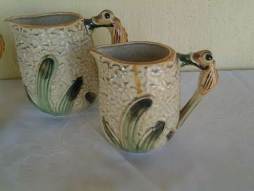 A set of three vintage bee style porcelain decorative porcelain jugs