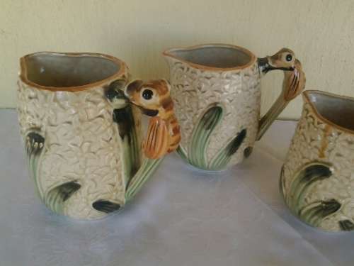 A set of three vintage bee style porcelain decorative porcelain jugs