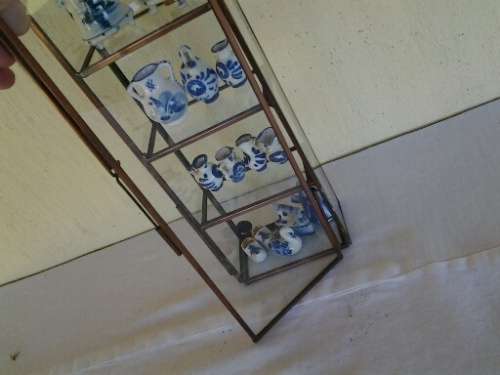 stunning little glass display case with some blue and white miniatures