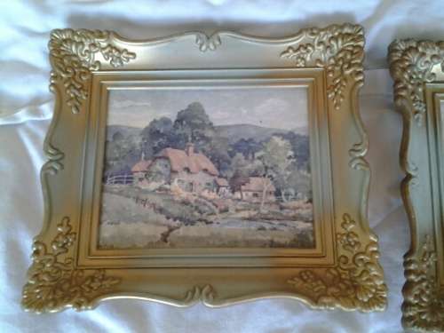A pair of small pretty hard plastic ornate frames with painted home scenes