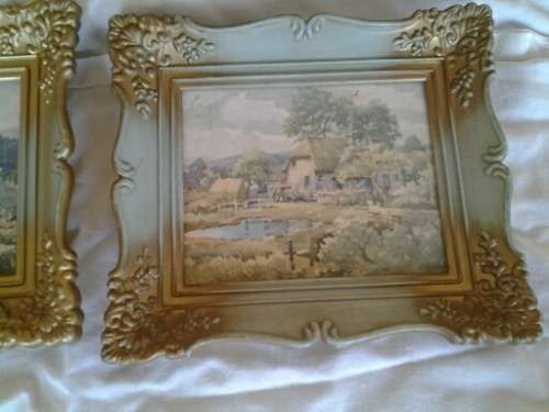 A pair of small pretty hard plastic ornate frames with painted home scenes