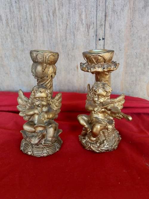 A pair of modern cherub resin candles holders