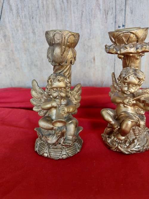 A pair of modern cherub resin candles holders