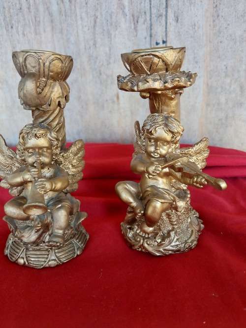 A pair of modern cherub resin candles holders