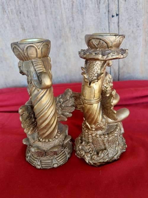 A pair of modern cherub resin candles holders