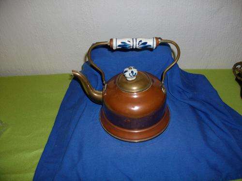 copper kettle with blue and white handle and top