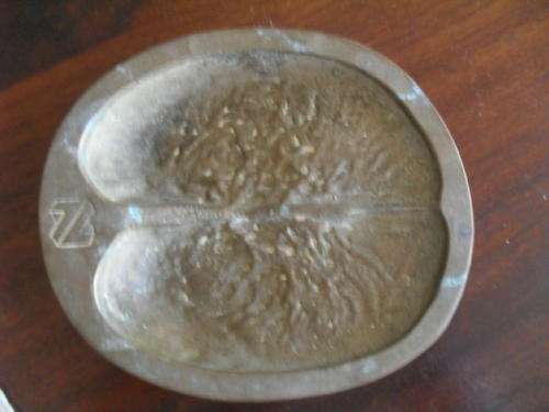 An AFRICAN BUFFALO SPOOR -ASHTRAY imprinted into a 2KG CHUNK OF BRASS.