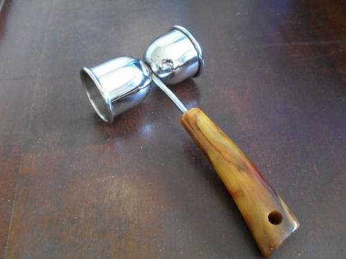 A TOT MEASURE WITH A UNIQUE HANDLE.