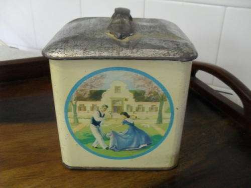 A VINTAGE COOKIE TIN -HANDLE ON THE LID.  PICTURES OF DANCING LADIES