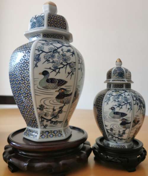 Japanese Meiji style Vases with lids on wooden bases.