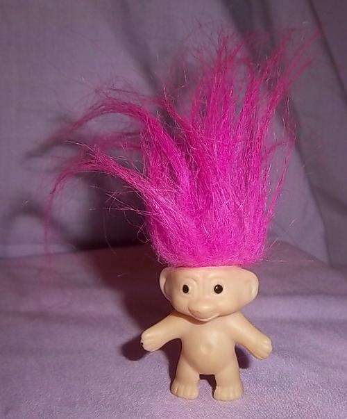 A SMALL PINK HAIR TROLL THAT FITS ON A PEN