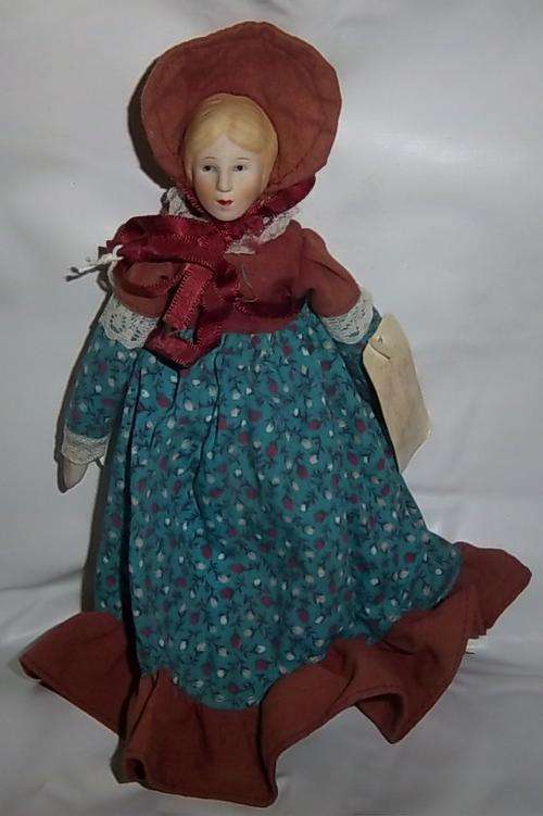 A PORCELAIN AND CLOTH DOLL BY RUSS