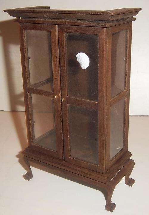 A VINTAGE BALL AND CLAW WOODEN DISPLAY CABINET FOR A DOLL HOUSE