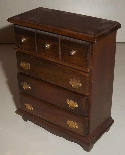 A WOODEN CHEST OF DRAWERS FOR A DOLL HOUSE