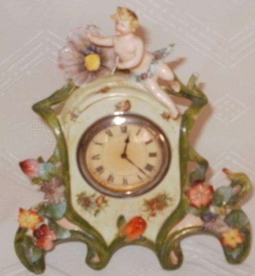 A STUNNING PORCELAIN CLOCK WITH CHERUB MOTIVE