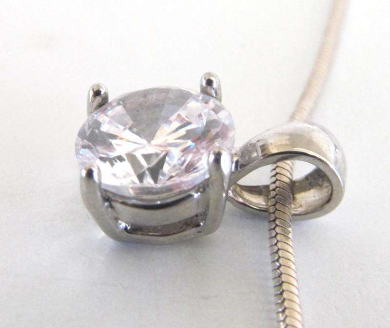 A SOLID SILVER PENDANT ON A SILVER SNAKE CHAIN PLUS SIMILAR PLATED EARRINGS