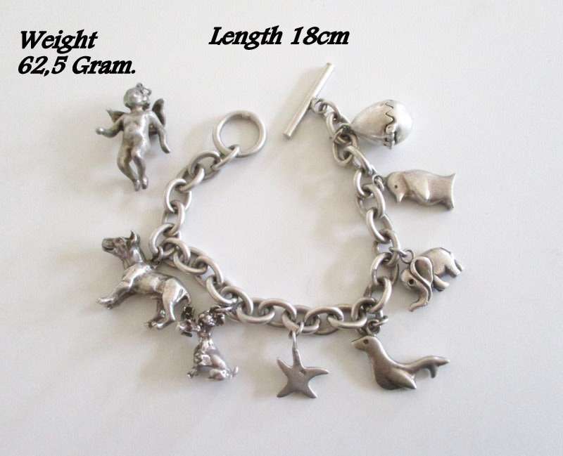 A HEAVY SOLID SILVER CHARM BRACELET WITH LARGE AND MEDIUM SIZE CHARMS--62,5 Gram