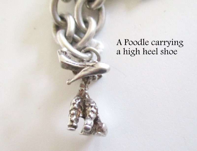 A HEAVY SOLID SILVER CHARM BRACELET WITH LARGE AND MEDIUM SIZE CHARMS--62,5 Gram
