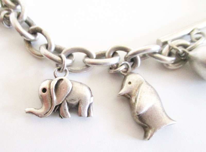 A HEAVY SOLID SILVER CHARM BRACELET WITH LARGE AND MEDIUM SIZE CHARMS--62,5 Gram