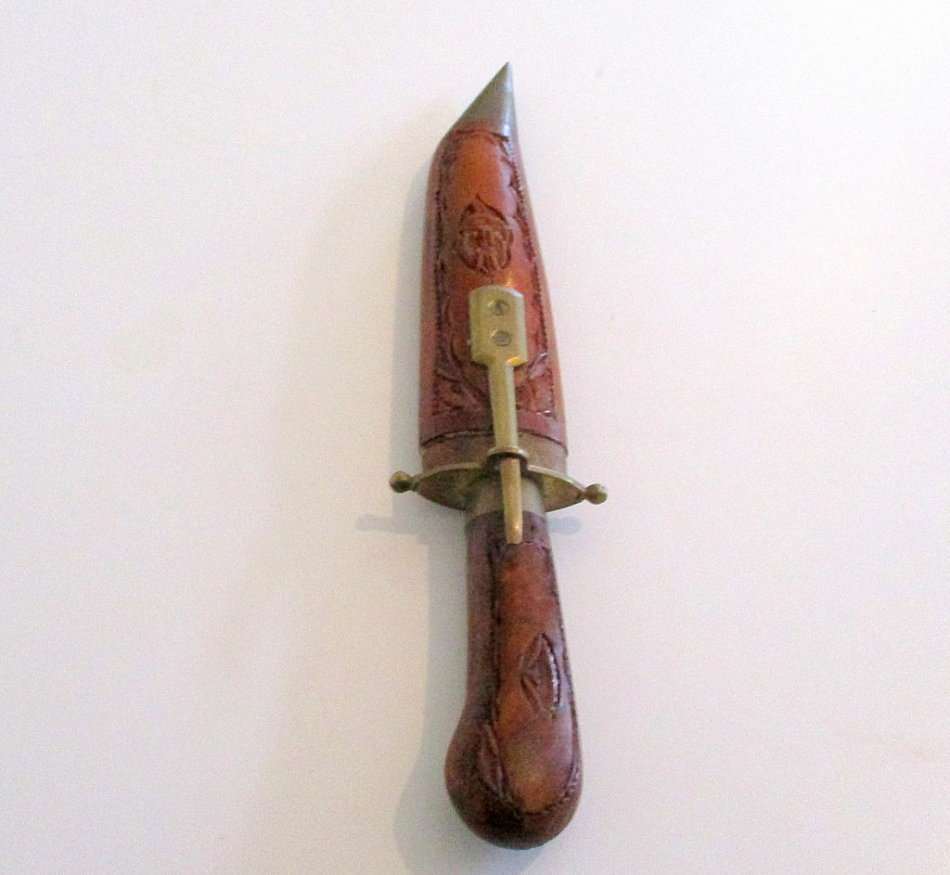A KNIFE/DAGGER WITH A CARVED WOODEN SHEATH
