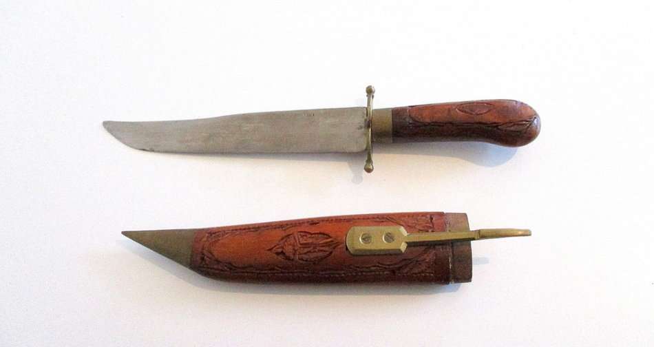 A KNIFE/DAGGER WITH A CARVED WOODEN SHEATH