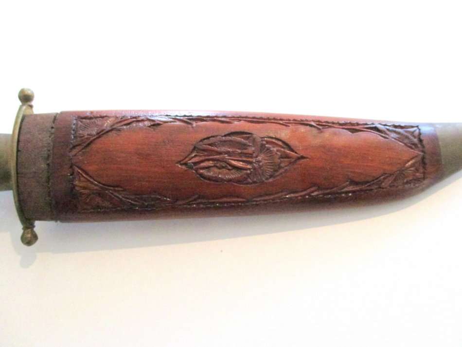 A KNIFE/DAGGER WITH A CARVED WOODEN SHEATH