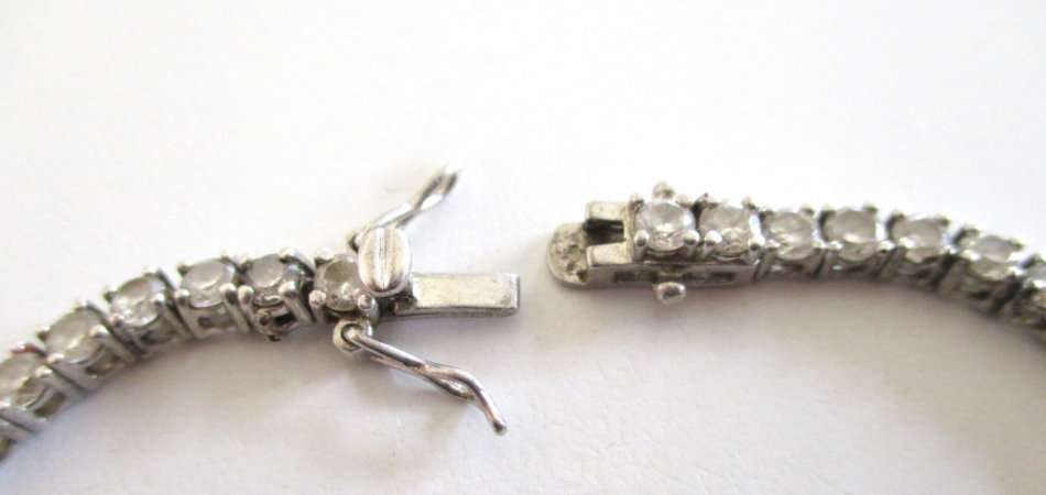 A SOLID SILVER TENNIS BRACELET WITH A WELL MADE CLASP--PLEASE SEE ALL IMAGES