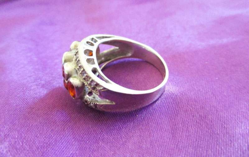 A SOLID SILVER RING WITH RED STONES