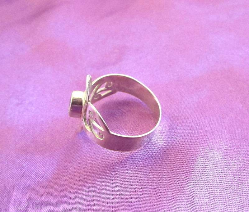 A SOLID SILVER RING WITH A CLEAR STONE