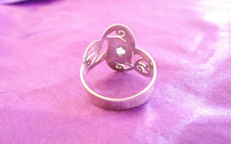 A SOLID SILVER RING WITH A CLEAR STONE