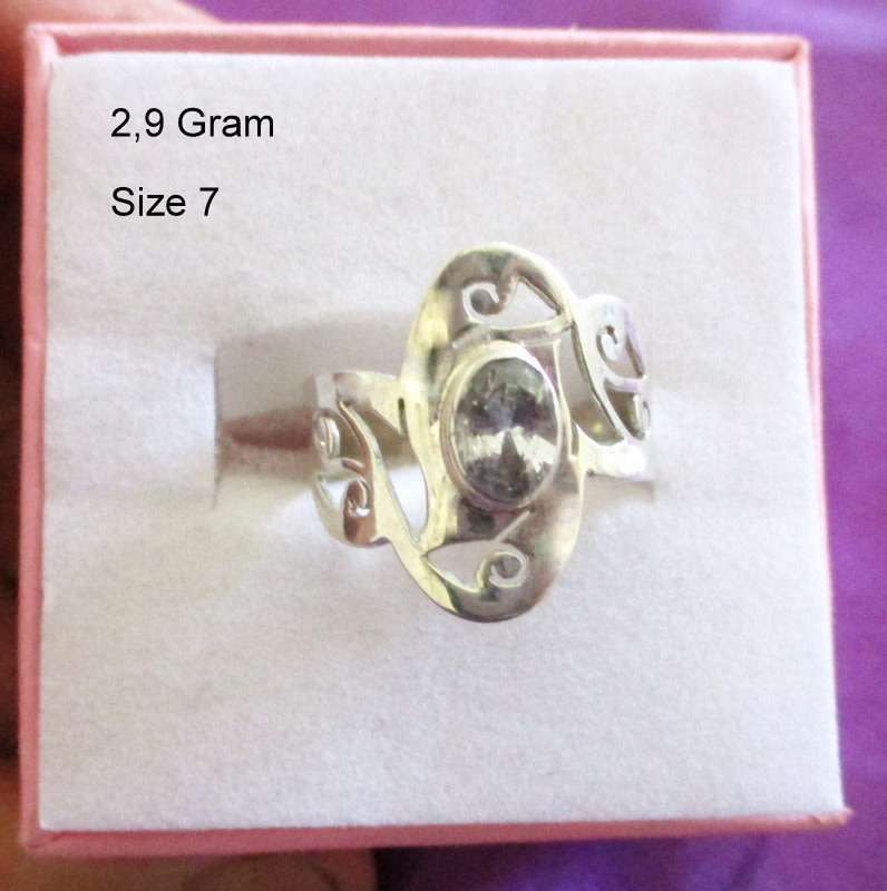 A SOLID SILVER RING WITH A CLEAR STONE