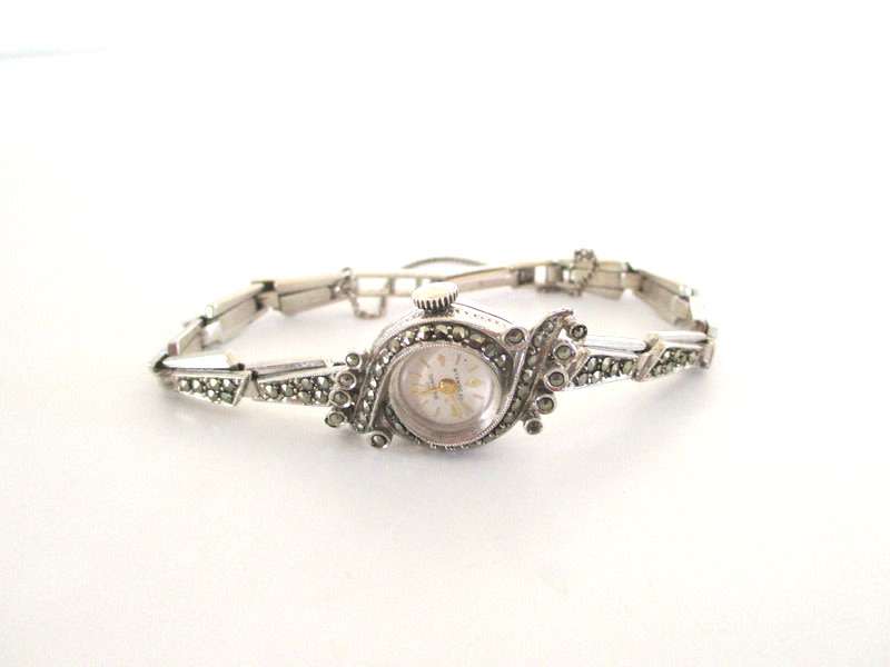 A STERLING SILVER MARCASITE (ALL INTACT) WATCH IN WORKING ORDER AND KEEPING TIME