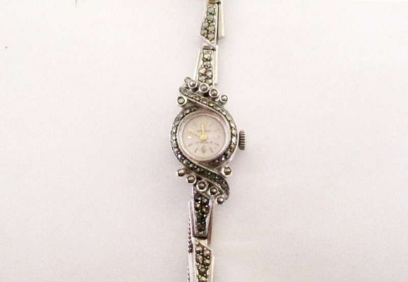 A STERLING SILVER MARCASITE (ALL INTACT) WATCH IN WORKING ORDER AND KEEPING TIME