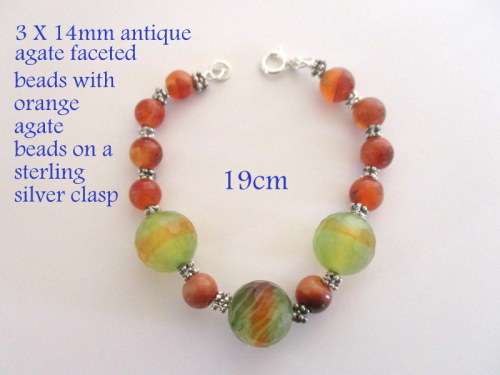 A BRACELET WITH 3 FAIRLY LARGE ANTIQUE FACETED AGATE AND OTHER AGATE BEADS ON A STERLING CLASP