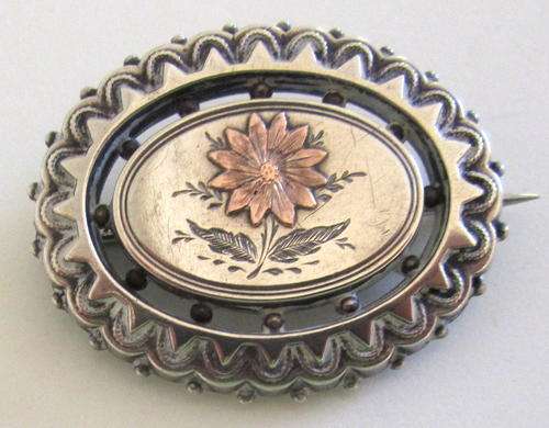 A LATE VICTORIAN SILVER AND GOLD FLOWER INSERT BROOCH.