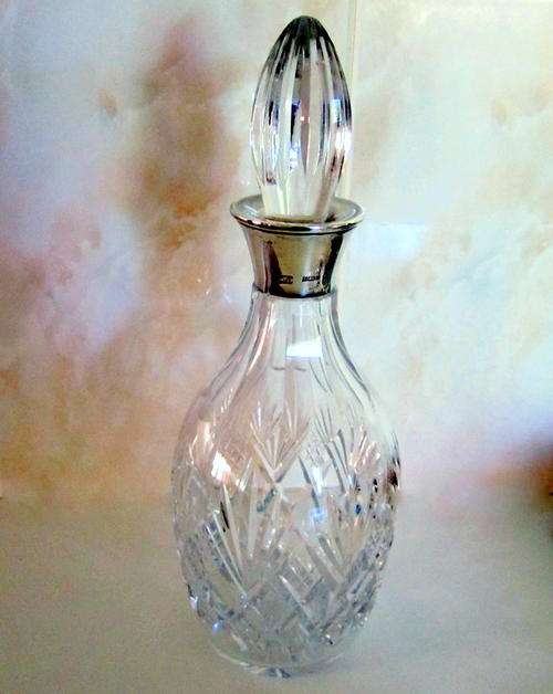 A CRYSTAL DECANTER WITH A HALLMARKED SILVER COLLAR