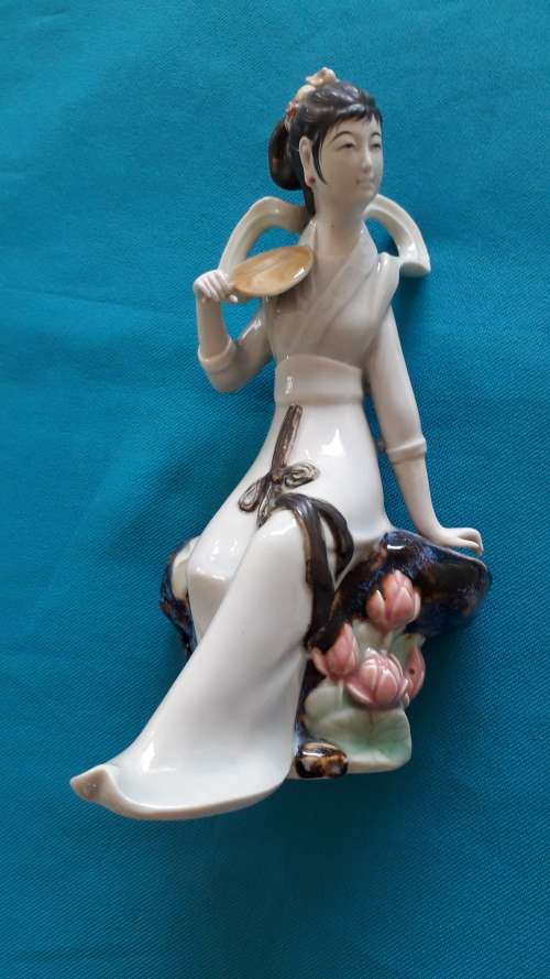 CERAMIC FIGURINE OF A SEATED GEISHA GIRL
