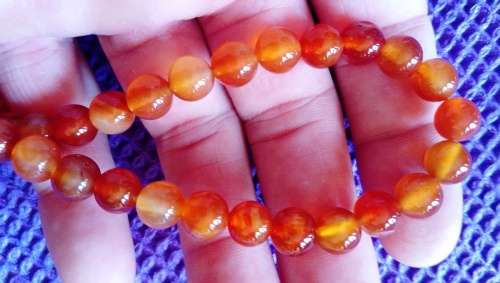 A GRADE TRANSLUCENT CARNELIAN GEMSTONE BEADS.  8 MM ROUND.  STRING IS 38 CM LONG.