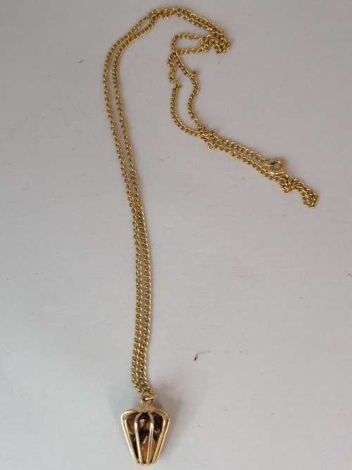 AN UNUSUAL CAGED TIGERS EYE PENDANT ON A GOLD TONE CHAIN